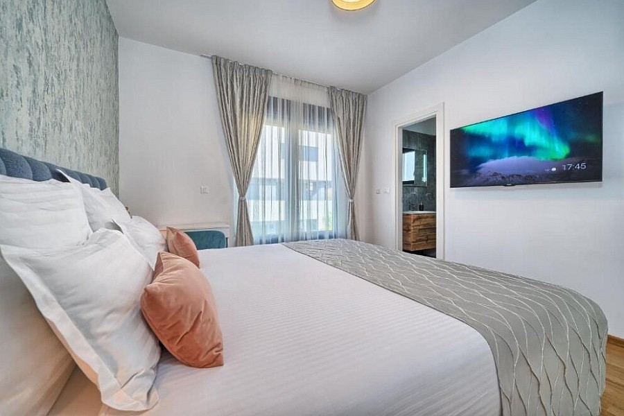 Schlafzimmer mit Doppelbett und Wandfernseher
