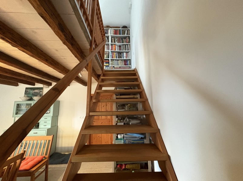 Holztreppe mit Bücherregal im Innenraum
