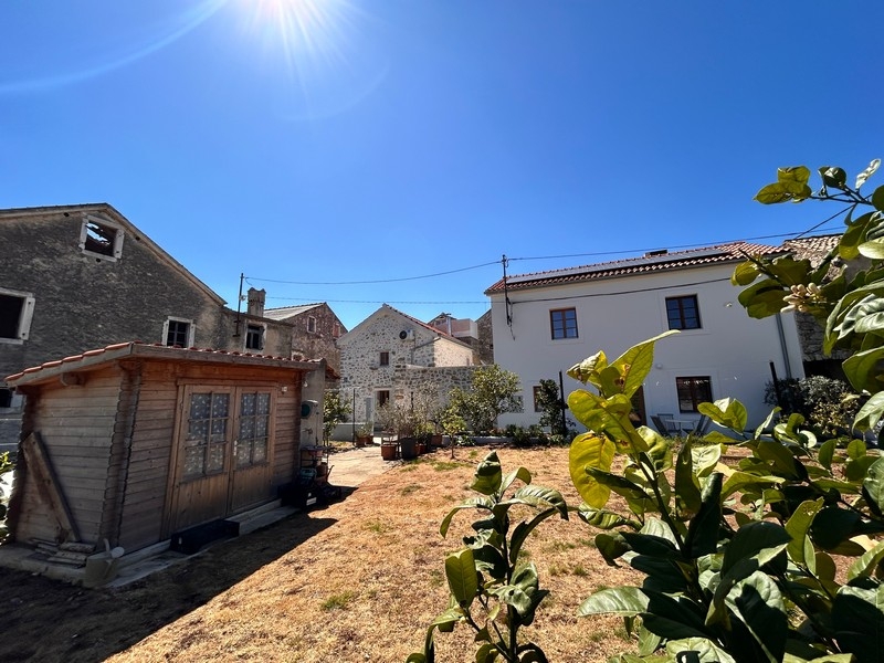 Garten mit Gartenhaus und Blick auf Steinhäuser