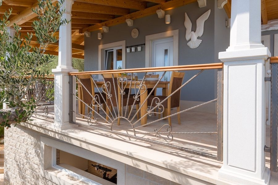 Überdachte Terrasse mit Geländer am Haus