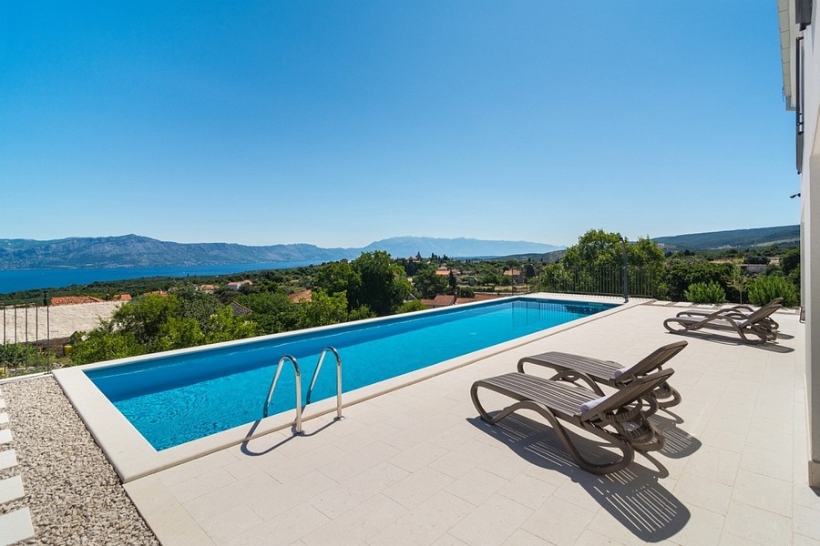 Pool mit Meerblick und Sonnenliegen