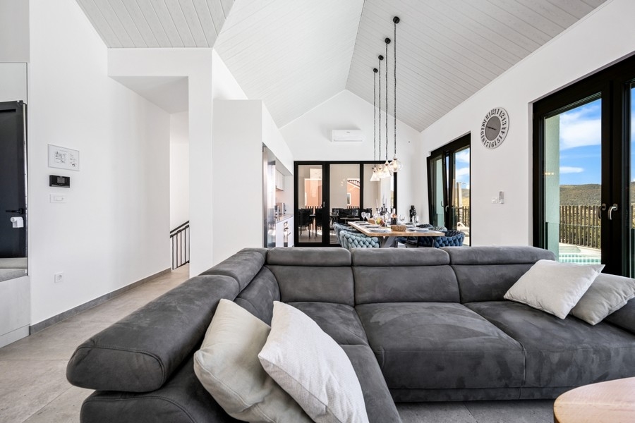 Wohnzimmer mit großem Ecksofa und Fensterfront