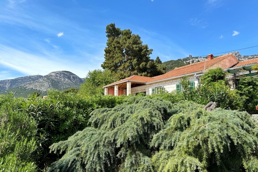 Mediterraner Garten mit Steinhäusern und Bergblick