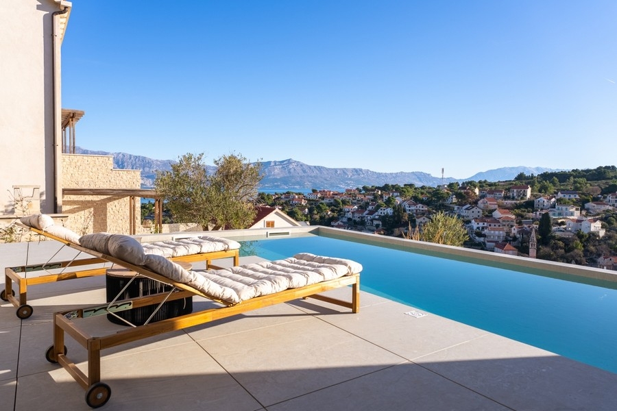 Swimmingpool mit Sonnenliegen und Blick über die Umgebung