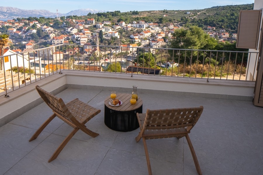 Terrasse mit Sitzplätzen und Blick über den Ort