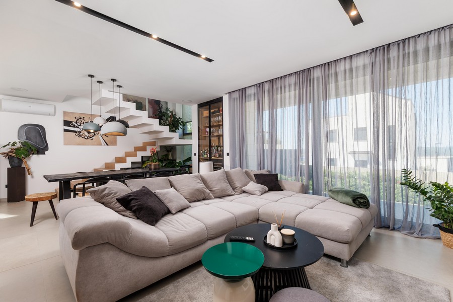 Offener Wohnbereich mit Sofa und Treppe