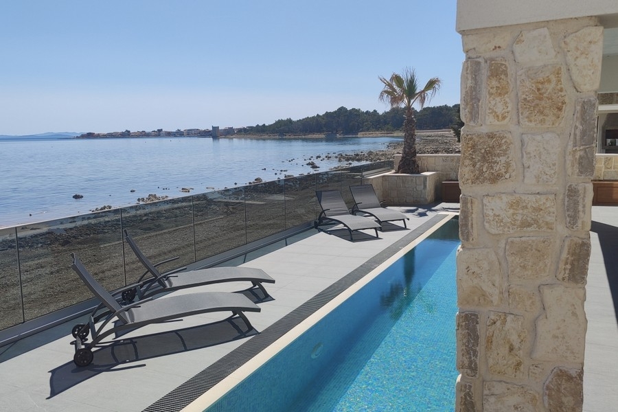 Sonnenliegen am Pool mit Blick auf das Meer