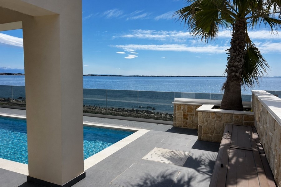 Poolbereich mit Palme und Meerblick