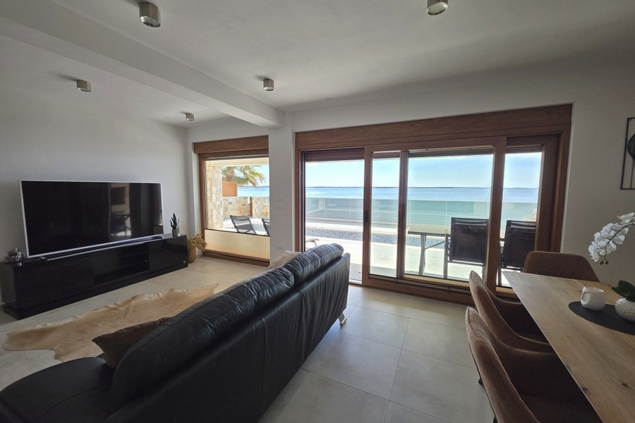 Wohnzimmer mit Schiebetür zur Terrasse am Meer