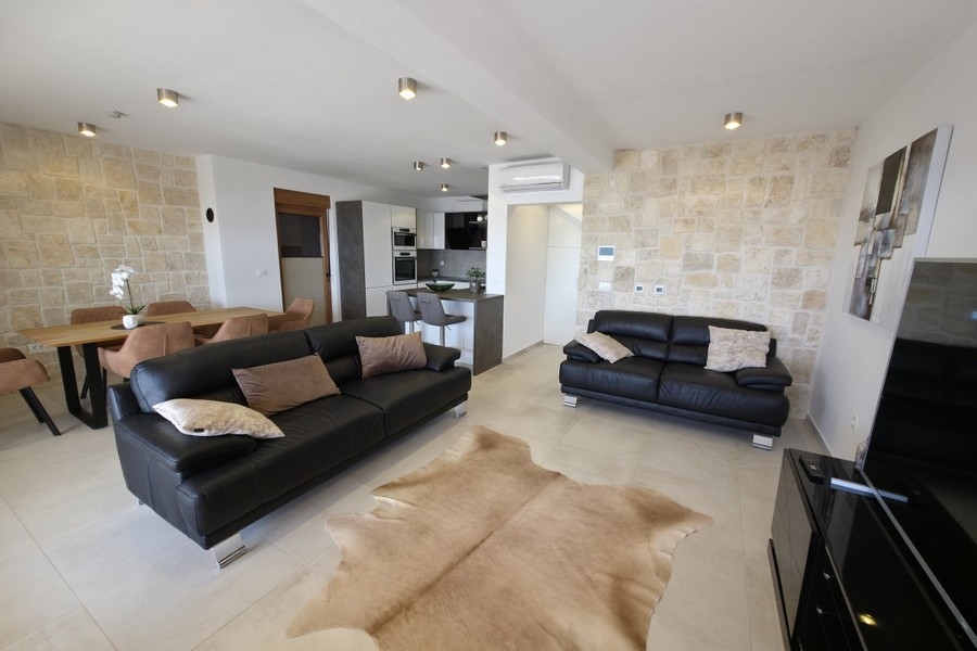 Wohnbereich mit Sofas und Natursteinwand