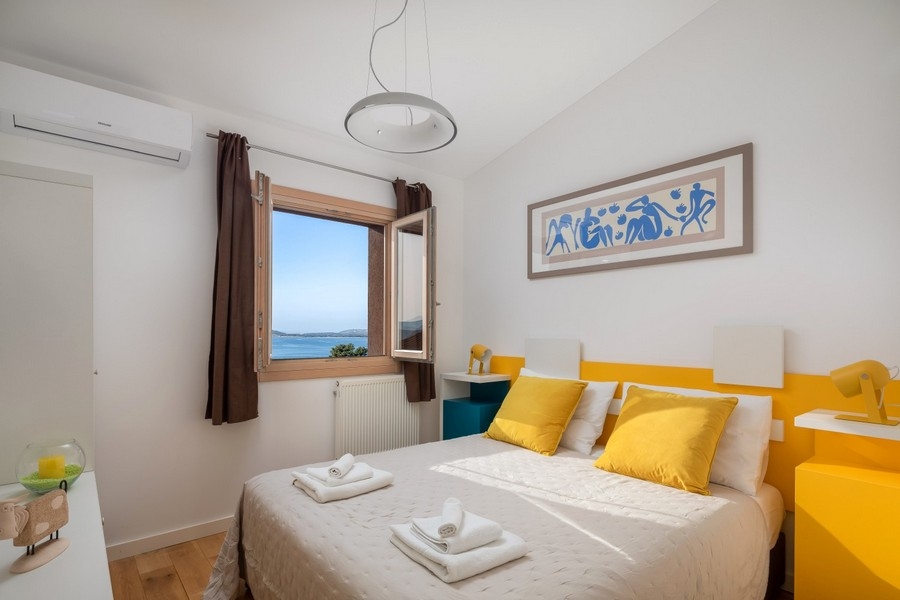 Schlafzimmer mit Meerblick und gelben Akzenten