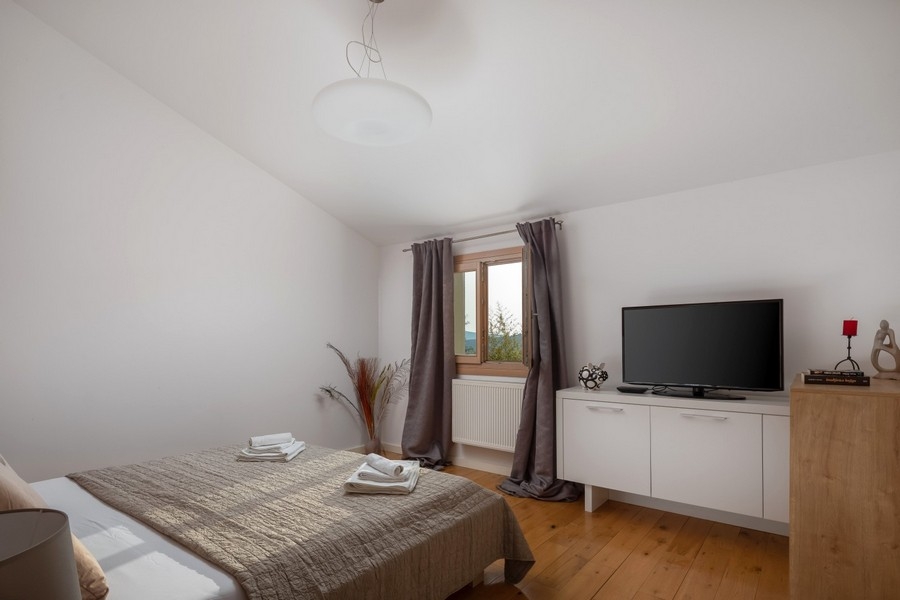 Schlafzimmer mit Doppelbett und Fernseher