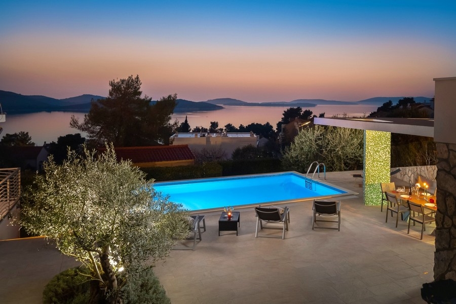 Pool mit Sommerküche und Meerblick am Abend