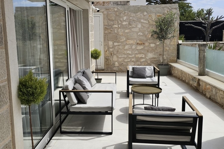 Terrasse mit Sitzbereich und Natursteinwand