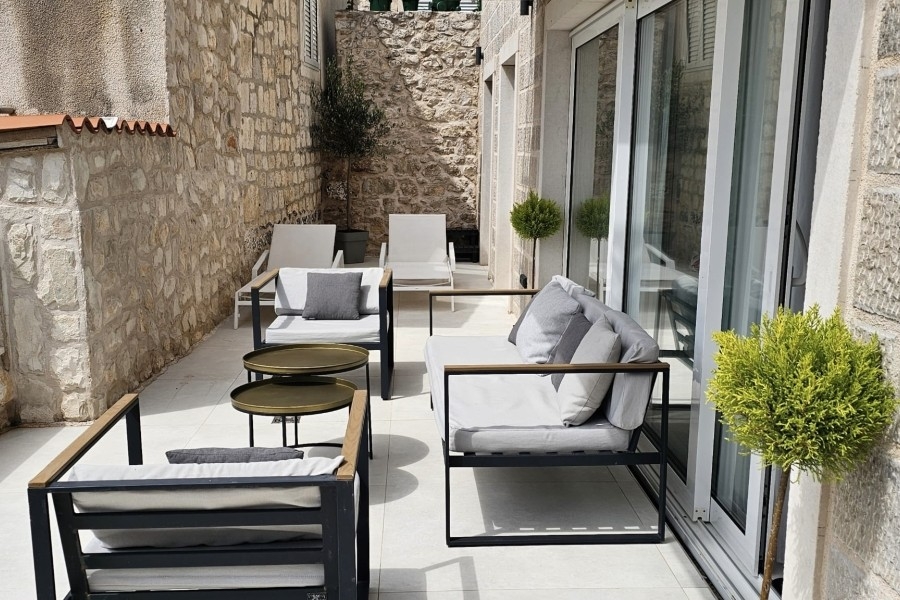 Terrasse mit Sesseln und Natursteinwand