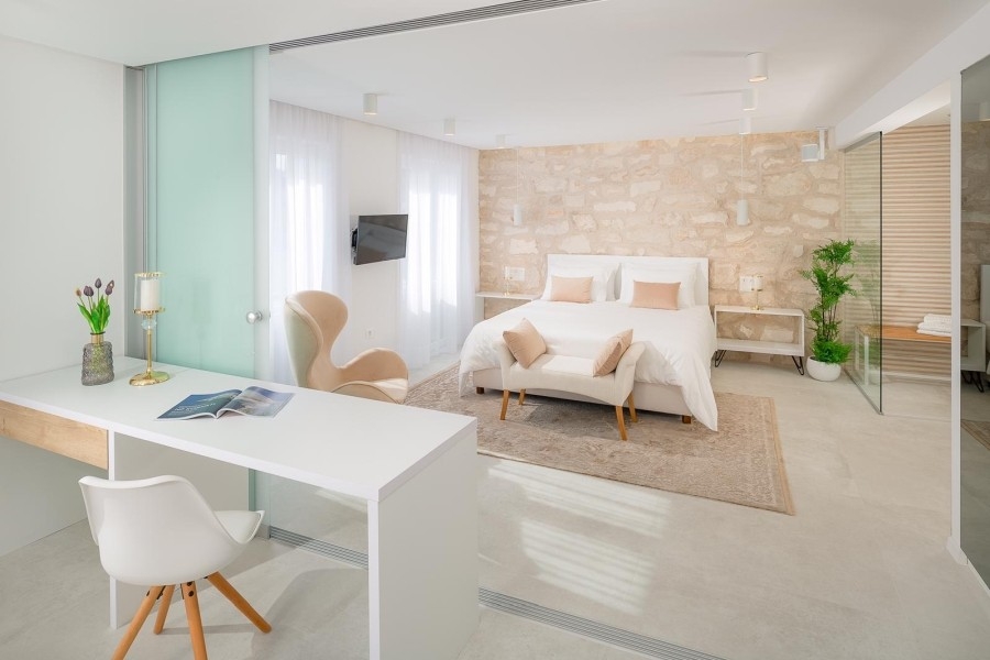 Schlafzimmer mit Natursteinwand und Arbeitsplatz