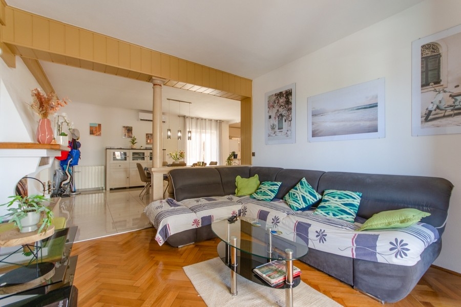 Wohnzimmer mit Eckcouch und offener Küche