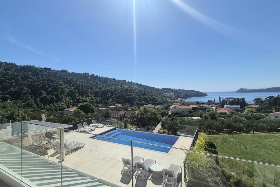 Poolterrasse mit Sonnenliegen und Meerblick