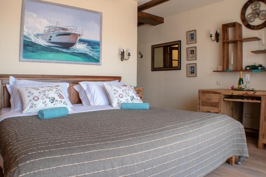 Schlafzimmer mit Doppelbett und maritimem Bild