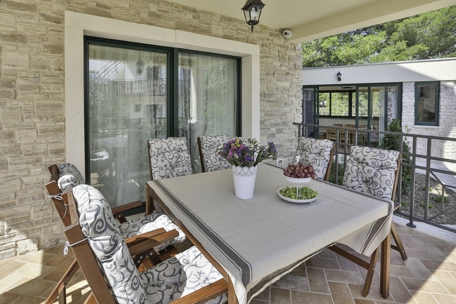 Überdachte Terrasse mit Sitzbereich und Tisch