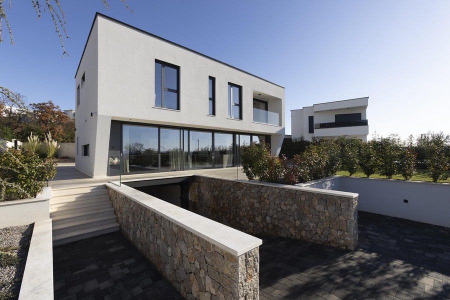 Außenansicht der Villa mit Natursteinmauer