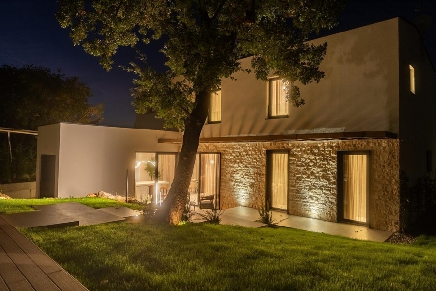 Beleuchtete Villa mit Steinfassade bei Nacht