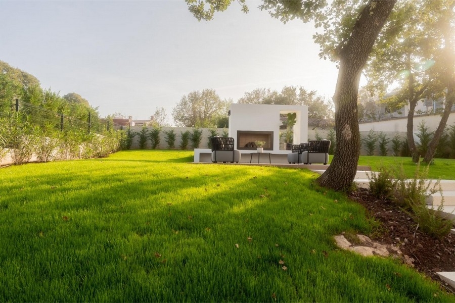 Garten mit Außenkamin und Loungesesseln