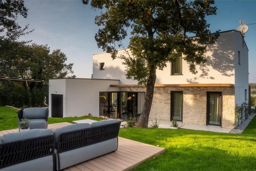 Villa mit Steinfassade und Lounge auf Holzdeck