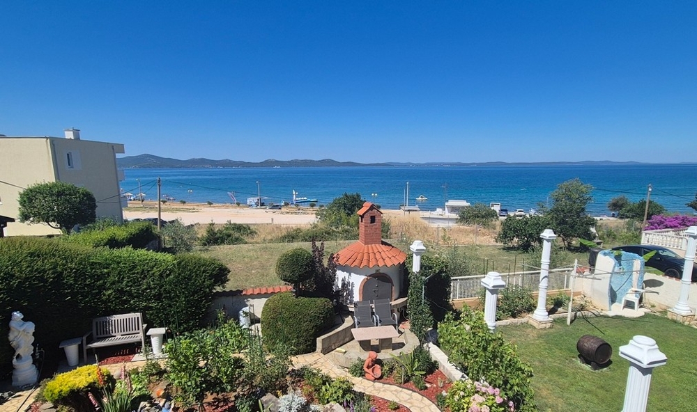Blick über den Garten auf Strand und Meer
