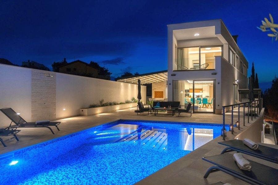 Moderne Villa mit beleuchtetem Pool am Abend auf Brac