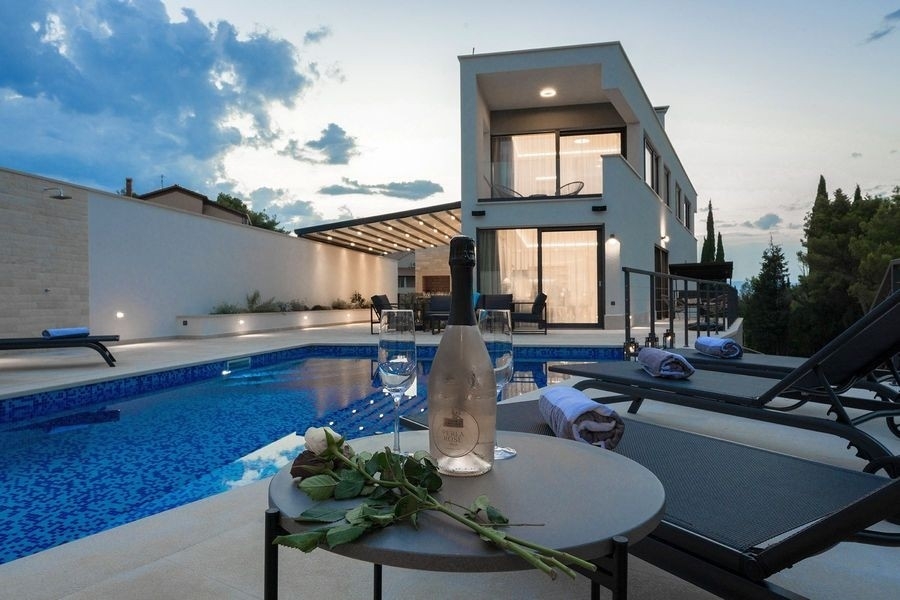 Poolterrasse mit Sonnenliegen am Abend