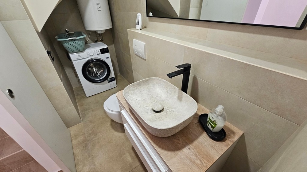 Badezimmer mit Waschbecken und Waschmaschine