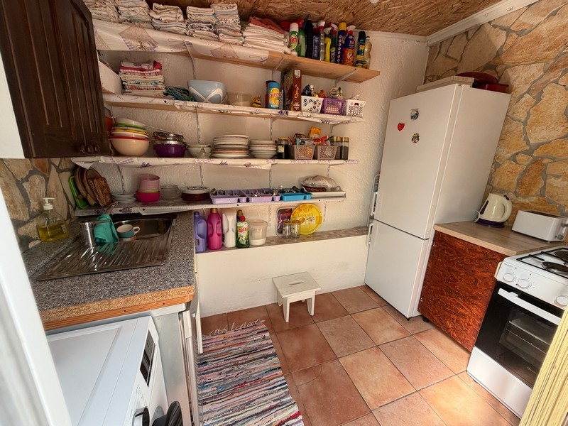 Sommerküche mit Kühlschrank und Regalen