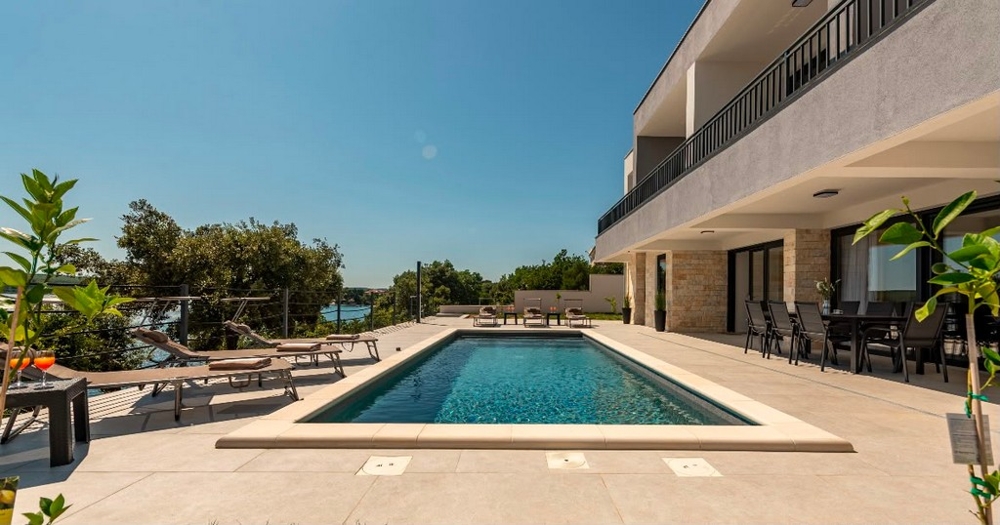 Swimmingpool mit Terrasse vor der Villa