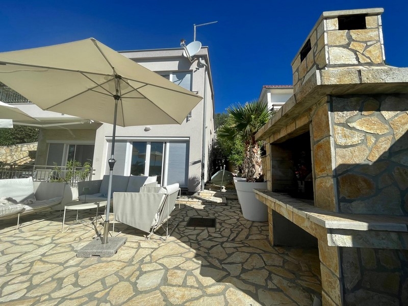 Terrasse mit gemauertem Steingrill und Sonnenschirm