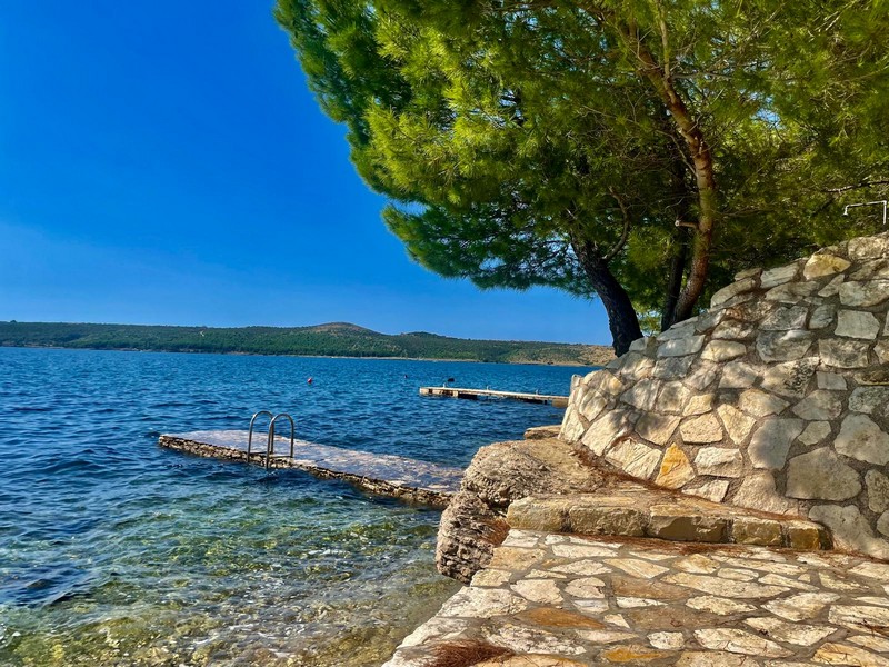 Steg am Wasser mit Natursteinmauer in Kroatien