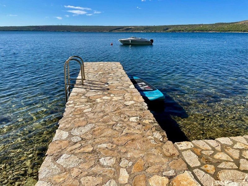 Steg mit Badeleiter am Wasser
