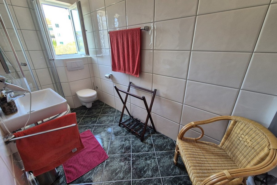Zweites Badezimmer mit Fenster und Toilette