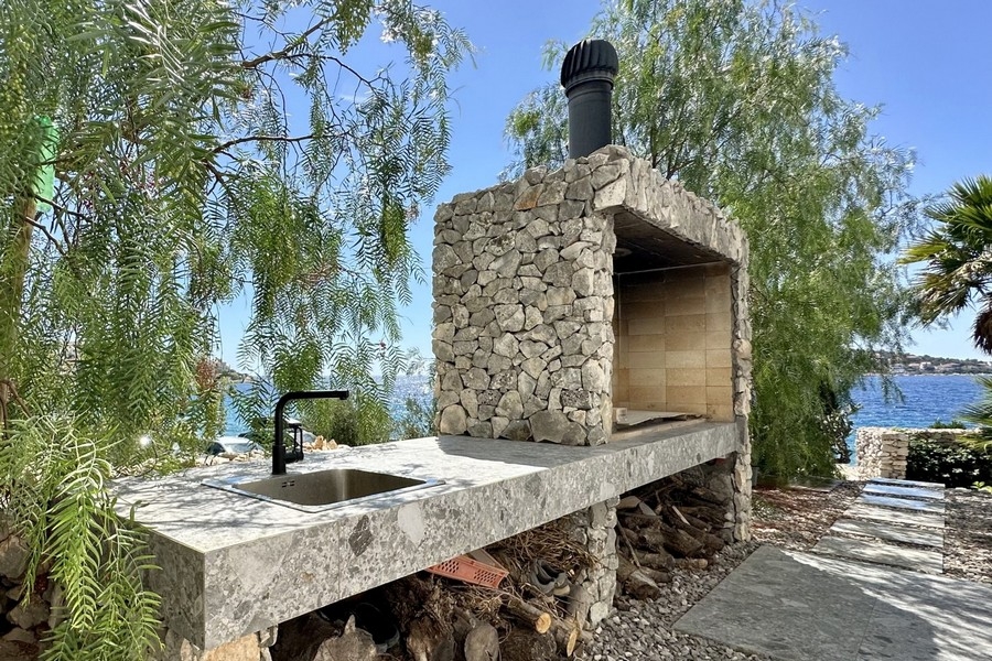 Gemauerter Außenkamin mit Grill und Spüle am Meer
