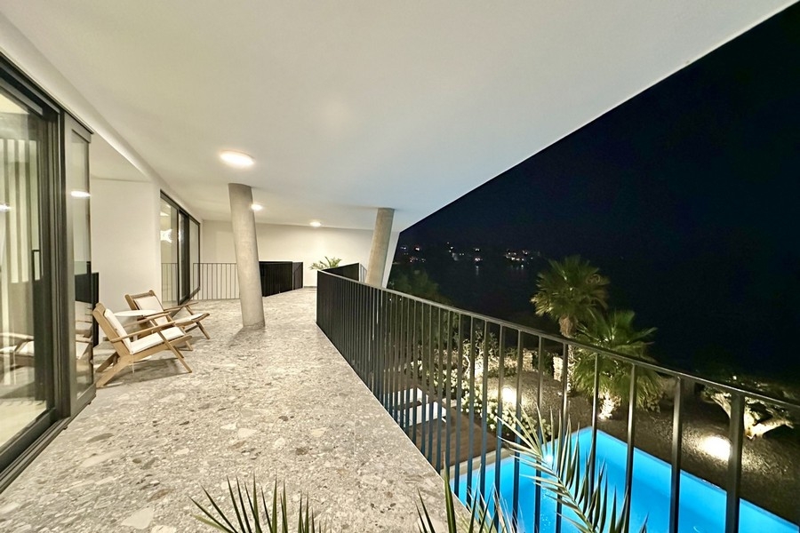 Überdachte Terrasse am Abend mit Blick auf die Bucht