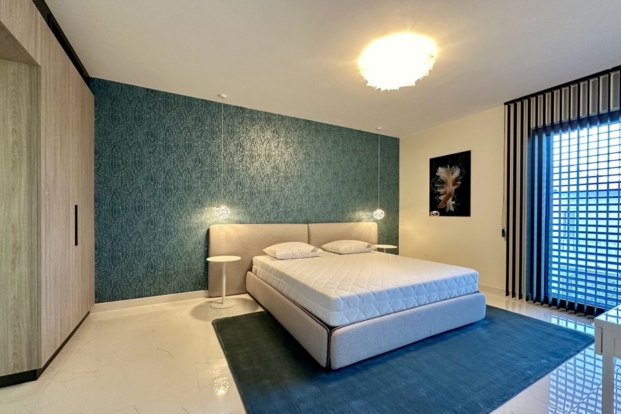 Schlafzimmer mit blauer Akzentwand und Doppelbett