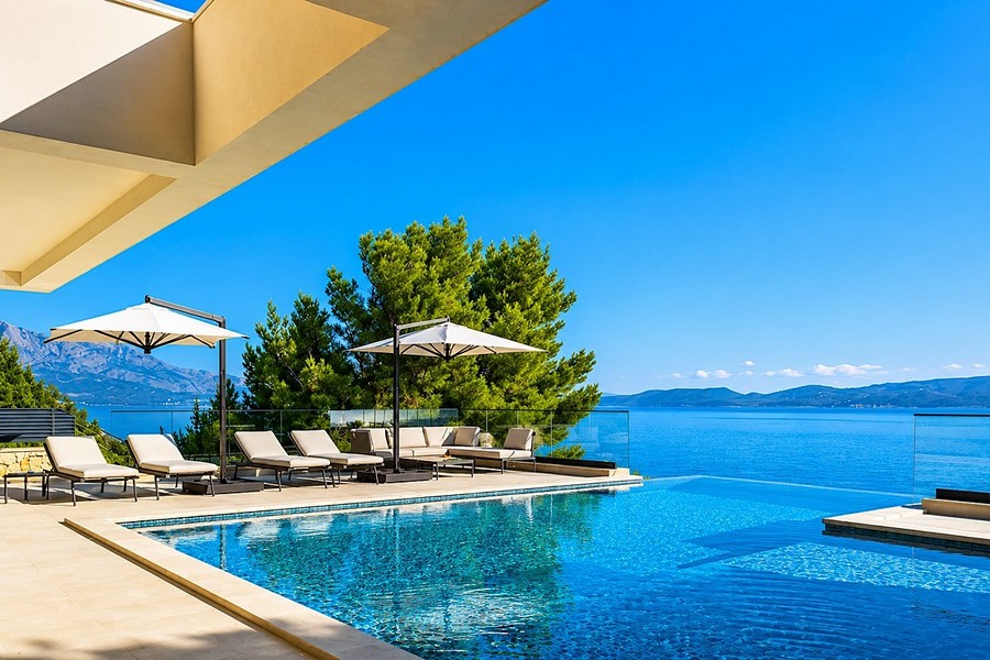 Poolterrasse mit Sonnenliegen und Meerblick