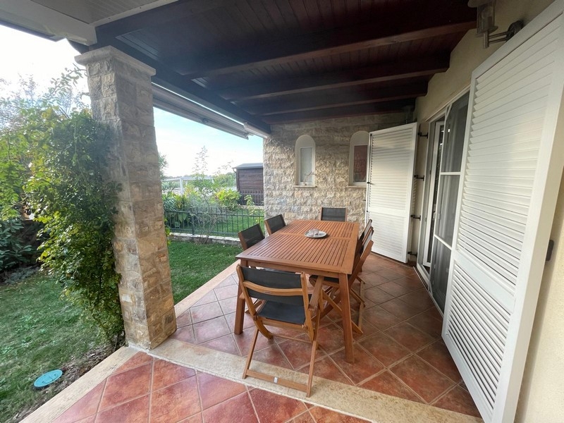 Überdachte Terrasse mit Sitzbereich und Garten