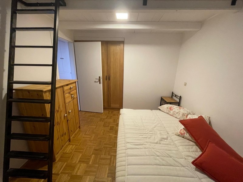 Schlafzimmer mit Holzmöbeln und Leiter zur Galerie