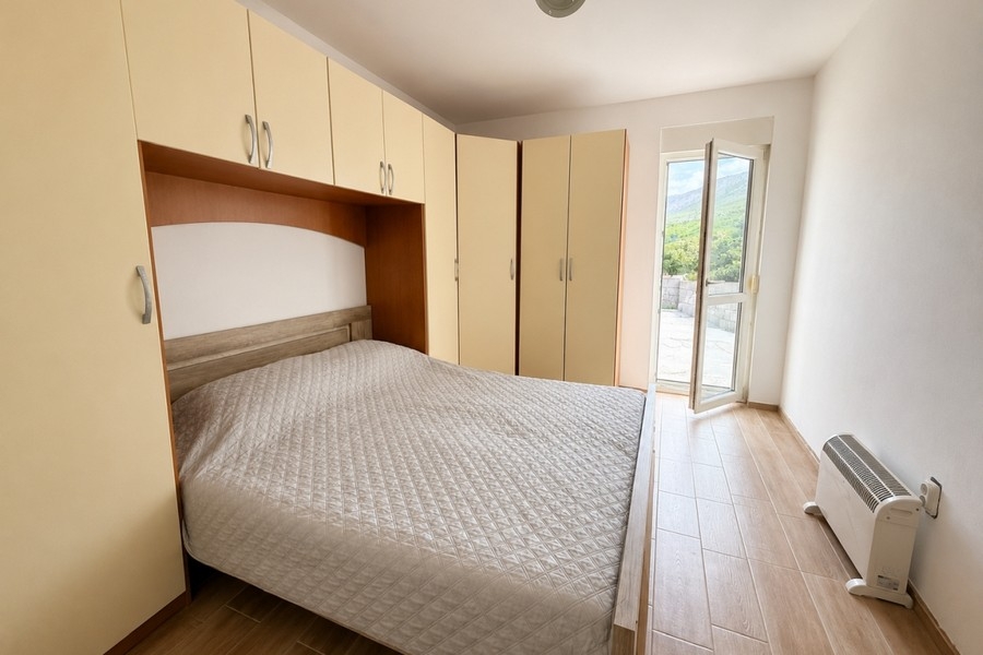 Schlafzimmer mit Einbauschränken und Zugang zur Terrasse