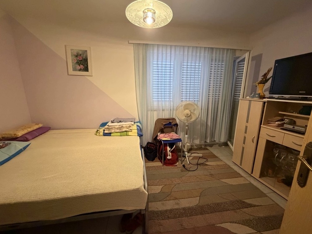 Schlafzimmer mit Doppelbett und Fernseher