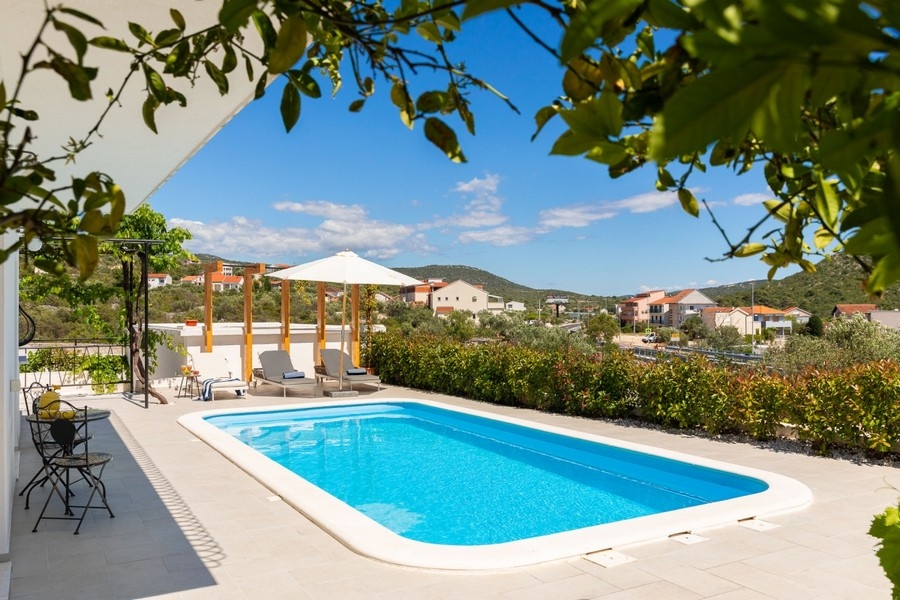 Poolterrasse mit Sonnenschirmen und Liegen