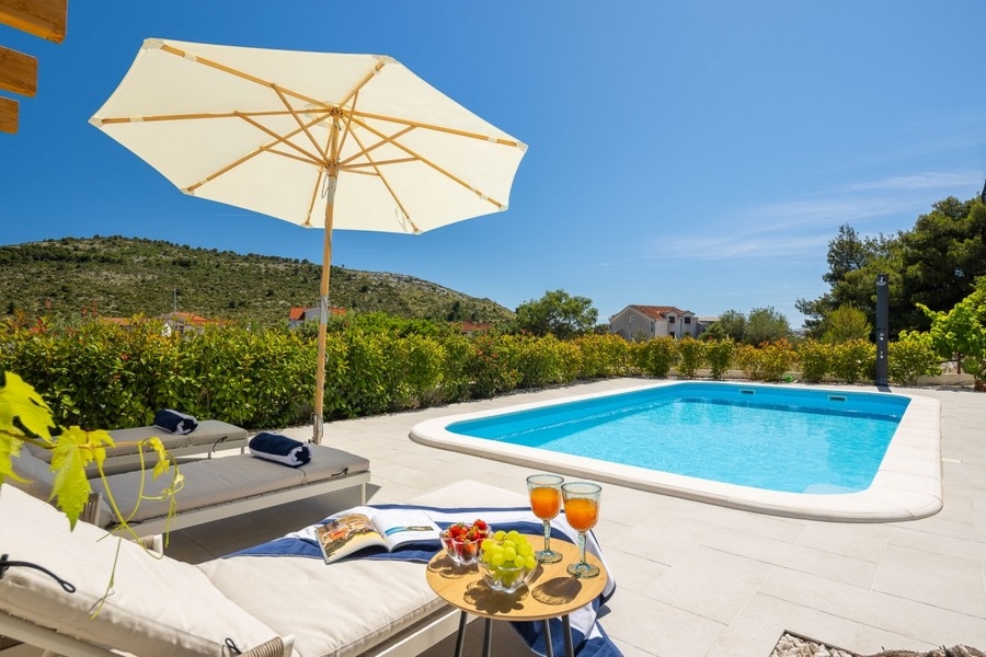 Sonnenliege und gedeckter Tisch am Pool