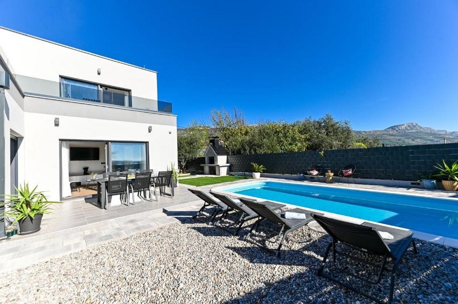 Außenbereich mit Pool und überdachtem Sitzplatz
