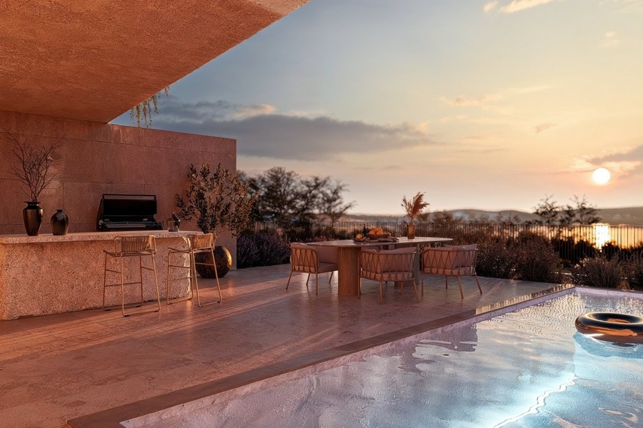 Swimmingpool im Abendlicht mit Blick auf das Meer